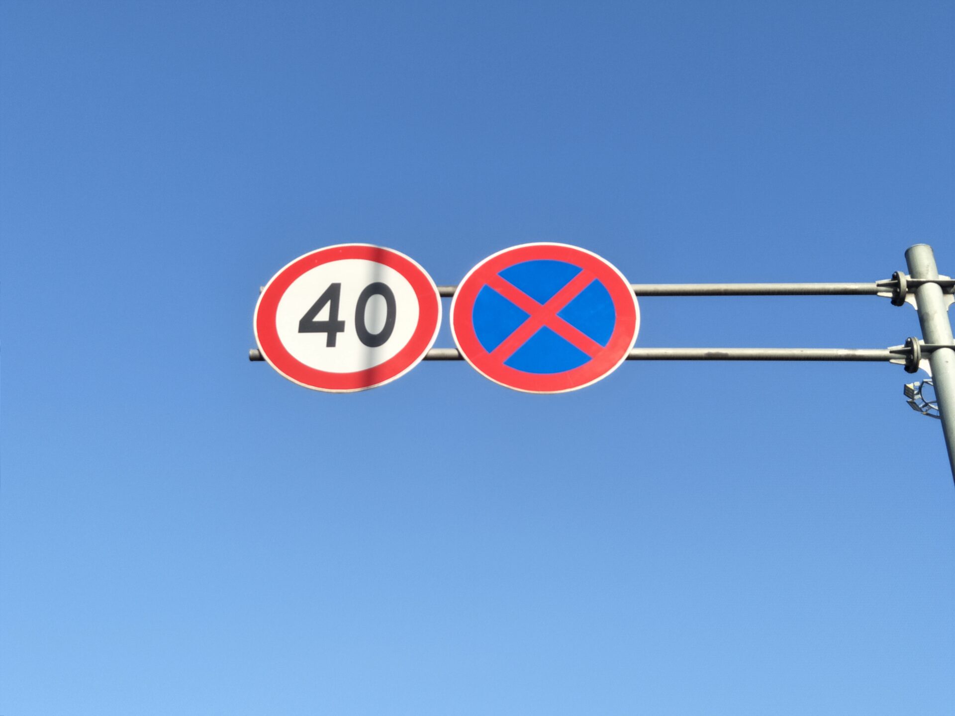 Bilde av to skilt, hvor det ene viser en fartsgrense på 40 kilometer i timen. Viktig å kunne skilt og trafikkregler når man skal ta motorsykkellappen.